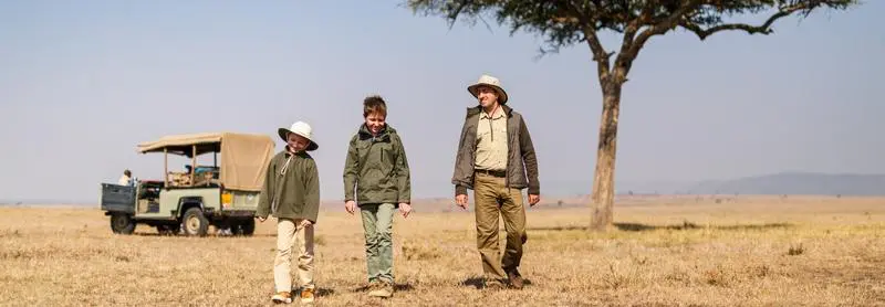 Man, boy and girl on a walking safari wearing traditional safari clothes