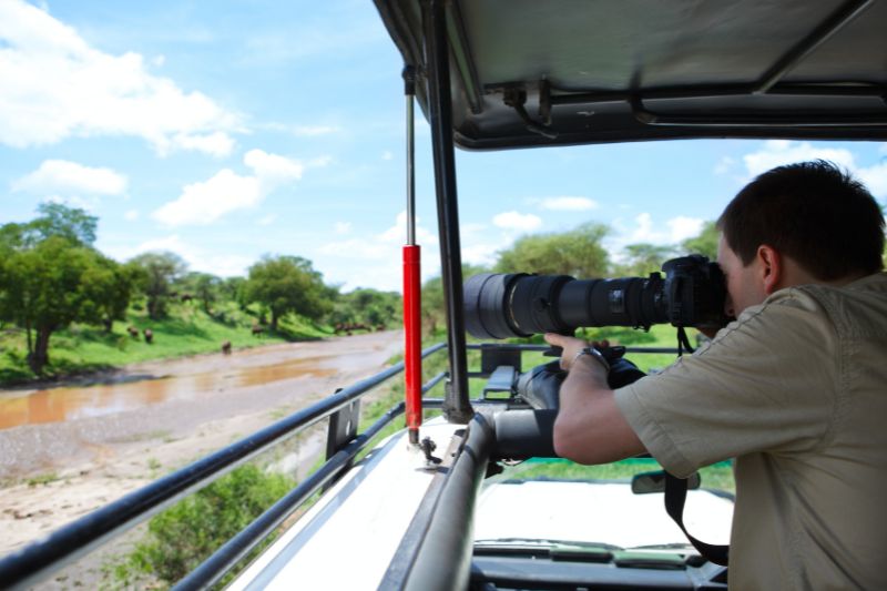 Man on photography safari in a jeep